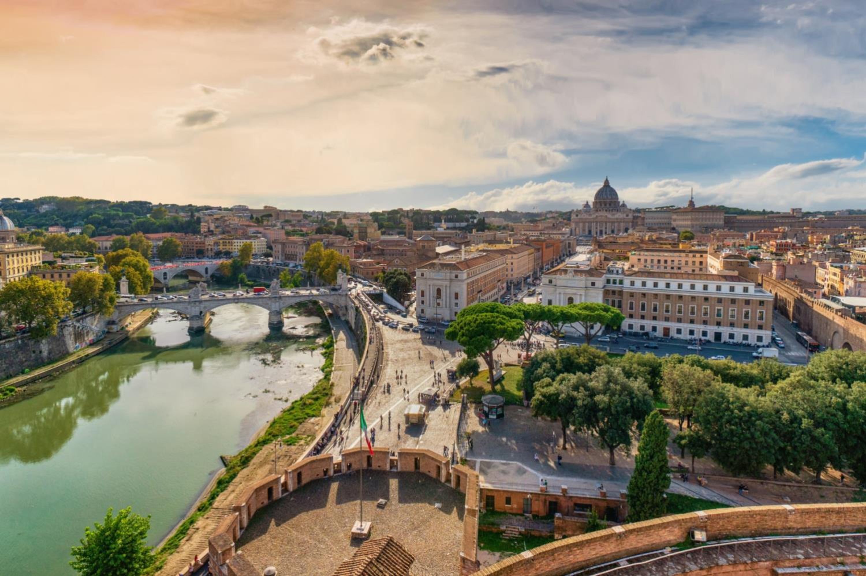 Un paisaje urbano con una cúpula destacada, un río y un puente.