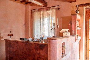 A kitchen with a marble countertop, a window with sheer curtains, and a wooden door. - Ottavia Residence Apartment Silver 3 Pax (Rome)
