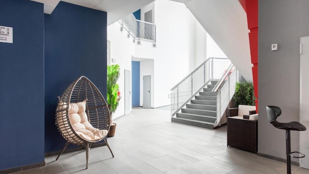 A modern interior with a hanging chair, a staircase, and a bar area. - Ottavia Residence Apartment Gold 2 Pax (Rome)