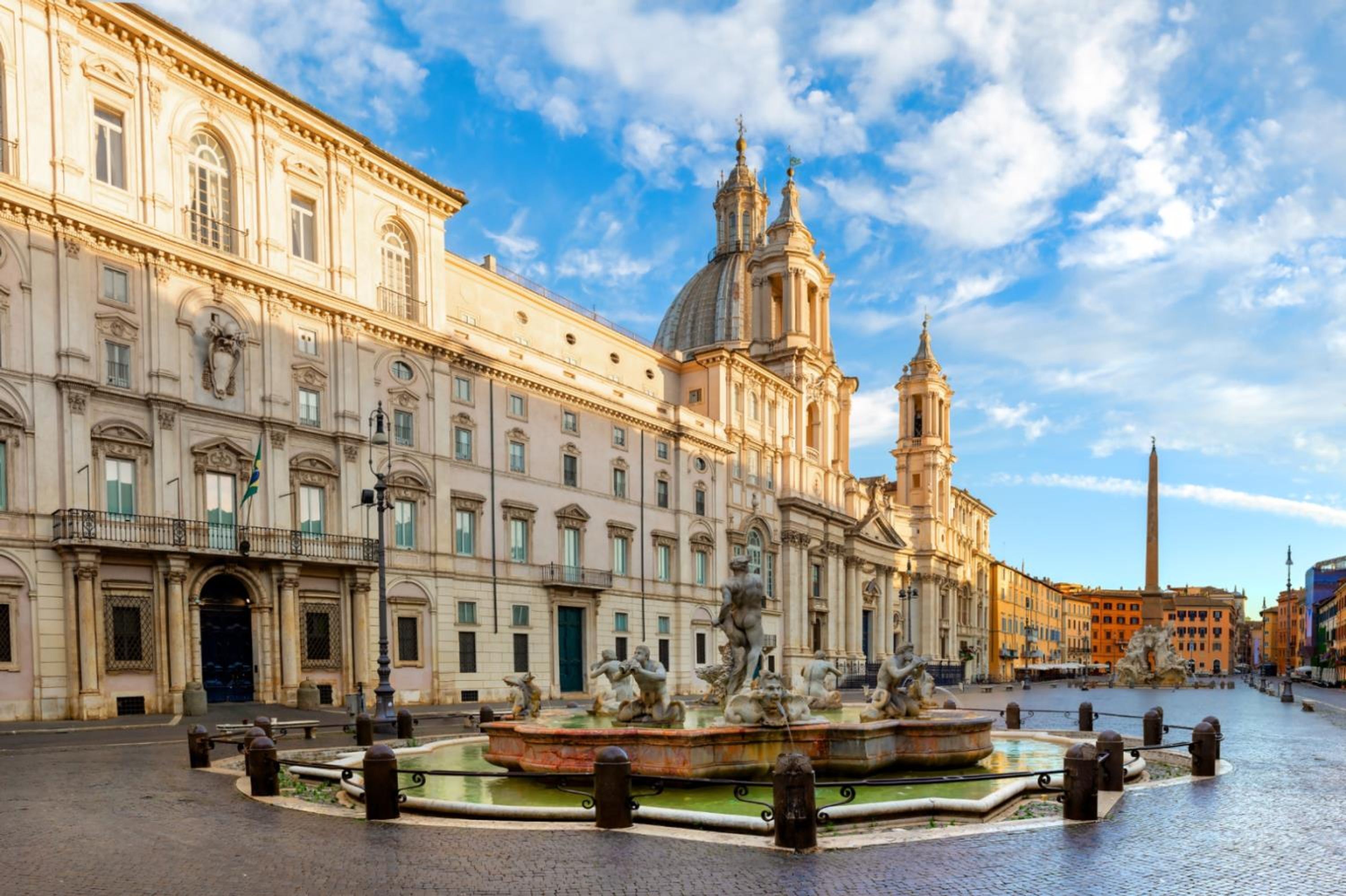 A historic building with classical architecture, a central fountain, and a prominent obelisk.