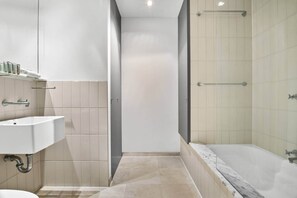 A modern bathroom with a sink, toilet, and bathtub. - Chic 2-Bed Apartment in Melbourne CBD (Melbourne)