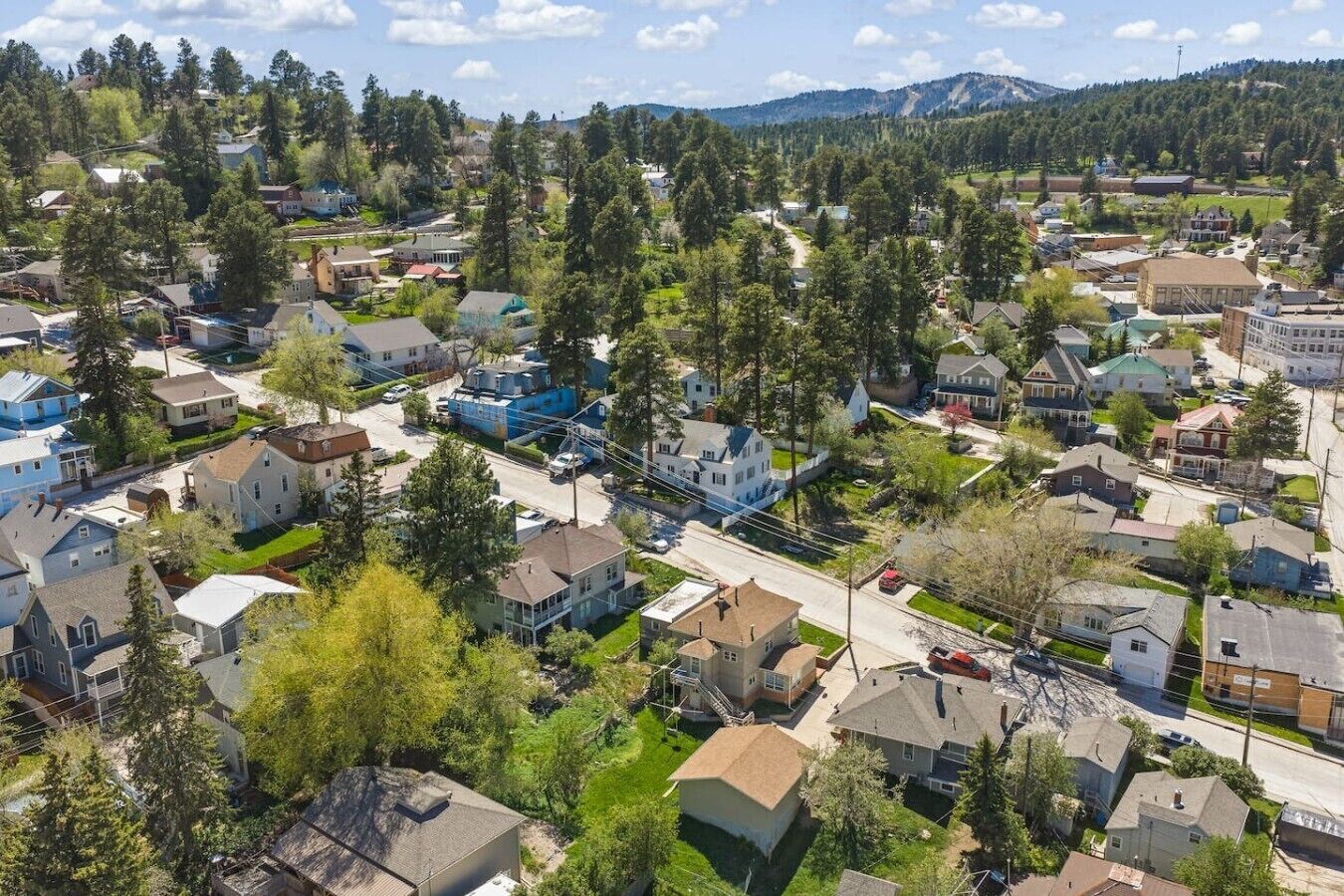 Vue aérienne d’un quartier résidentiel avec ses maisons, ses rues et la végétation environnante.