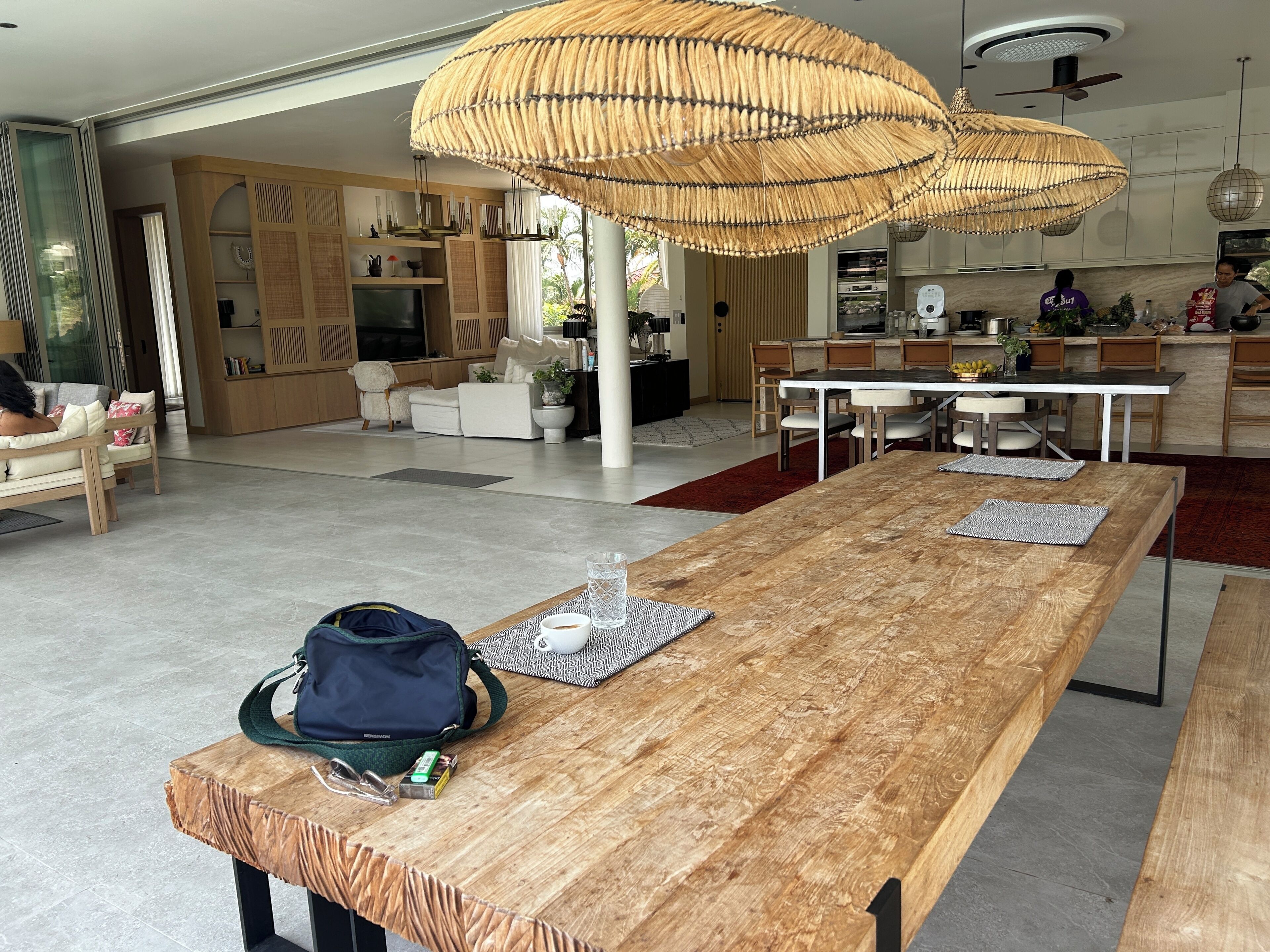 Ein geräumiger Wohnbereich mit einem langen Holztisch, einer bequemen Couch und einem Essbereich mit Stühlen.