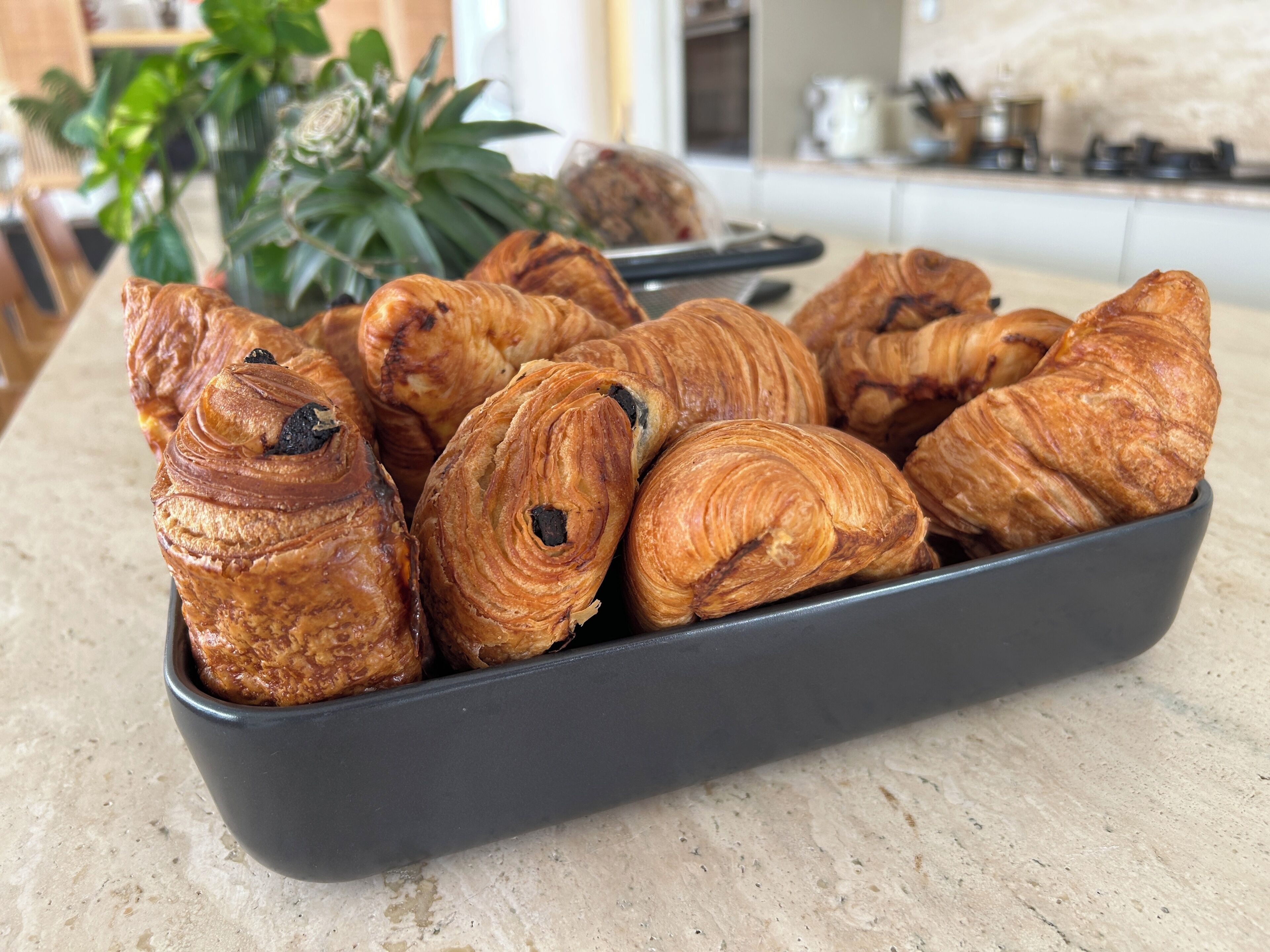 A tray of croissants on a kitchen counter.