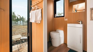 A compact bathroom with a toilet, sink, and towel rack.
