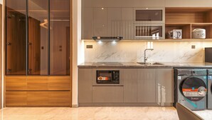Uma cozinha moderna com micro-ondas integrado, máquina de lavar loiça e máquina de café no balcão.