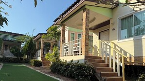 A two-story house with a covered porch, a staircase, and a well-maintained lawn. - Nada Koh Larn Resort (Koh Lan)