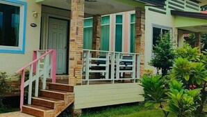 A two-story house with a porch, a staircase, and a well-maintained lawn. - Nada Koh Larn Resort (Koh Lan)