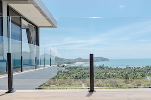 Un edificio moderno con un balcón que da a un paisaje costero.