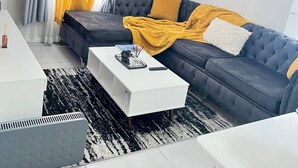 A modern living room with a sofa, coffee table, and a dining area. - Stylish 1BR Midrand Pool, Wifi & Secure Parking (Johannesburg)