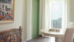 A room with a chessboard, a green door, a white chair, and a painting on the wall. - Wellness retreat with olive grove in Framura (Framura)