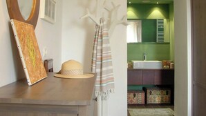 A bathroom with a green wall, a white sink, and a mirror. - Wellness retreat with olive grove in Framura (Framura)