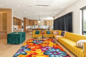 Un salon moderne avec un canapé, une table basse et un tapis aux couleurs vives.
