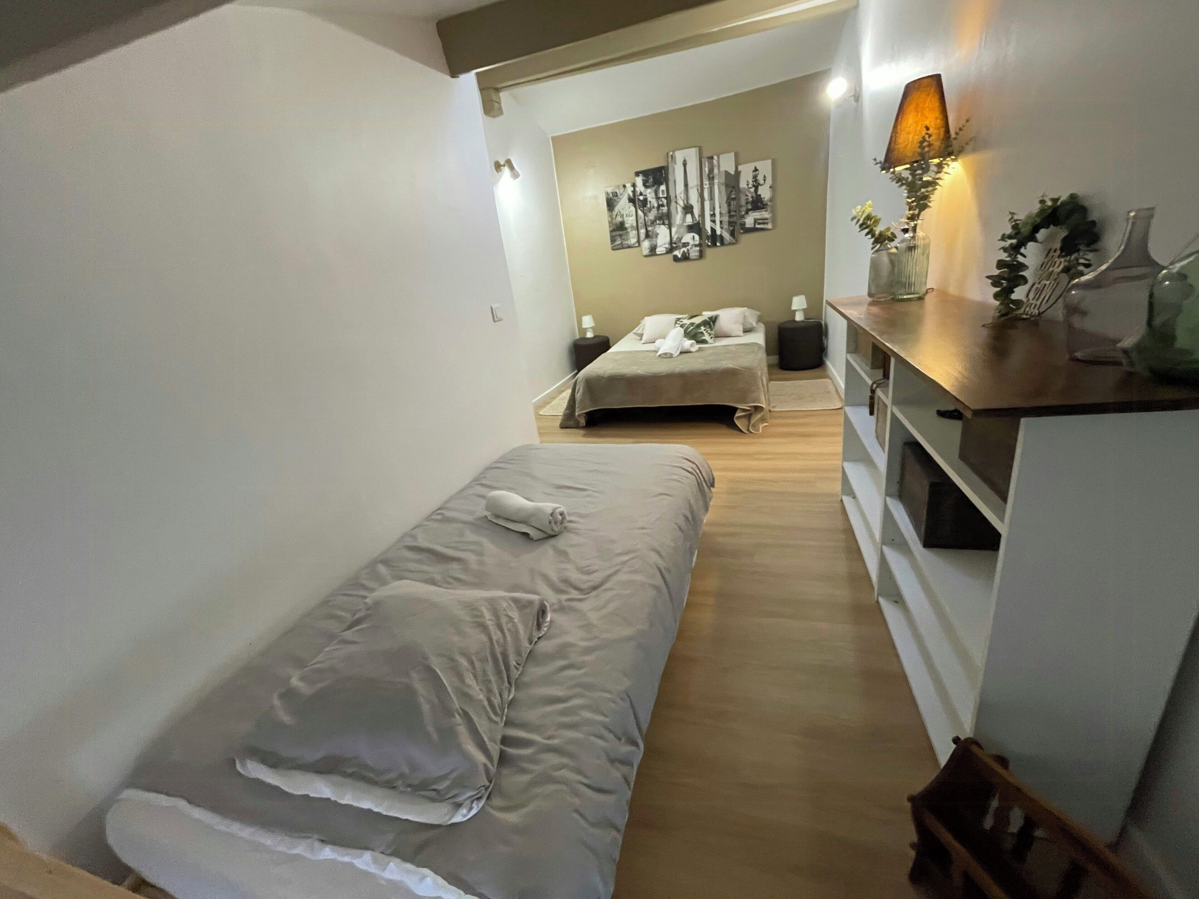 Un dormitorio con una cama individual, una mesita de noche, una lámpara y una obra de arte en la pared.