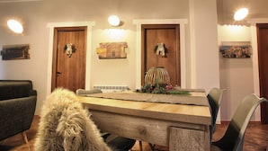 Zona pranzo con tavolo in legno, sedie e un elemento decorativo al centro.