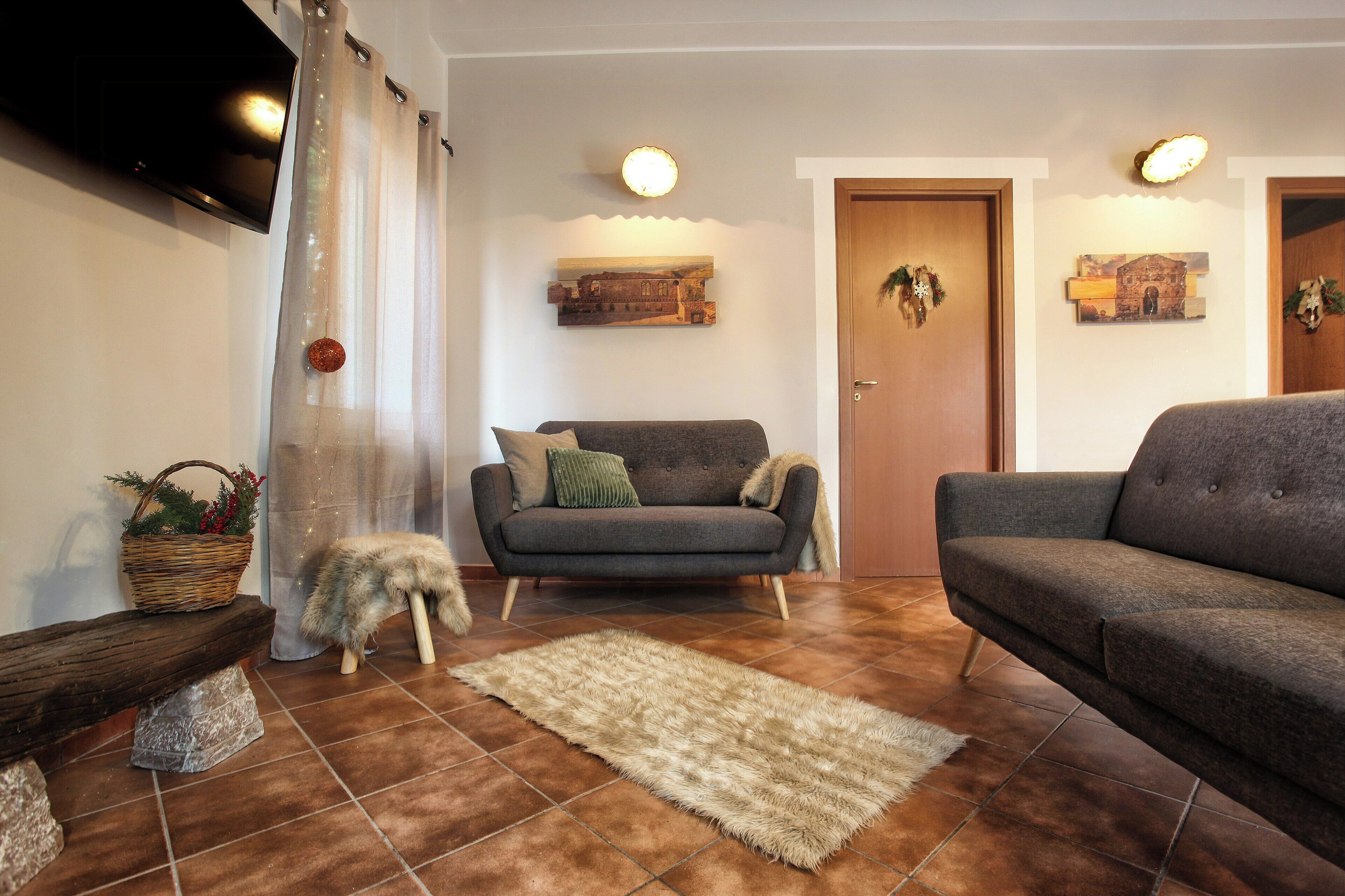A living room with a sofa, a bench, a rug, and a television.