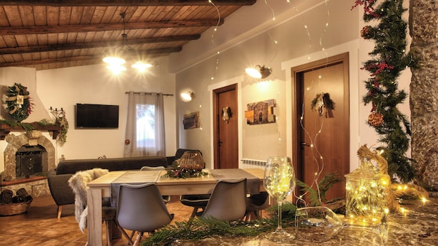 Un'accogliente sala da pranzo con un tavolo in marmo, sedie e decorazioni festive.