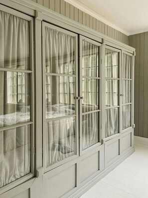 A room with a large, light-colored wardrobe with multiple doors and windows, each with curtains. - Converted school in Östergötland oak landscape (Tjällmo)