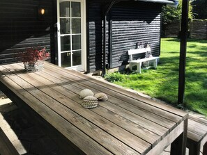A wooden deck with a bench, a small table, and a potted plant. - Summerhouse by Tisvilde Hegn forest (Tisvildeleje)