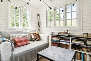 Ein gemütliches Zimmer mit einer Couch, einem Couchtisch und einem Bücherregal voller Bücher.