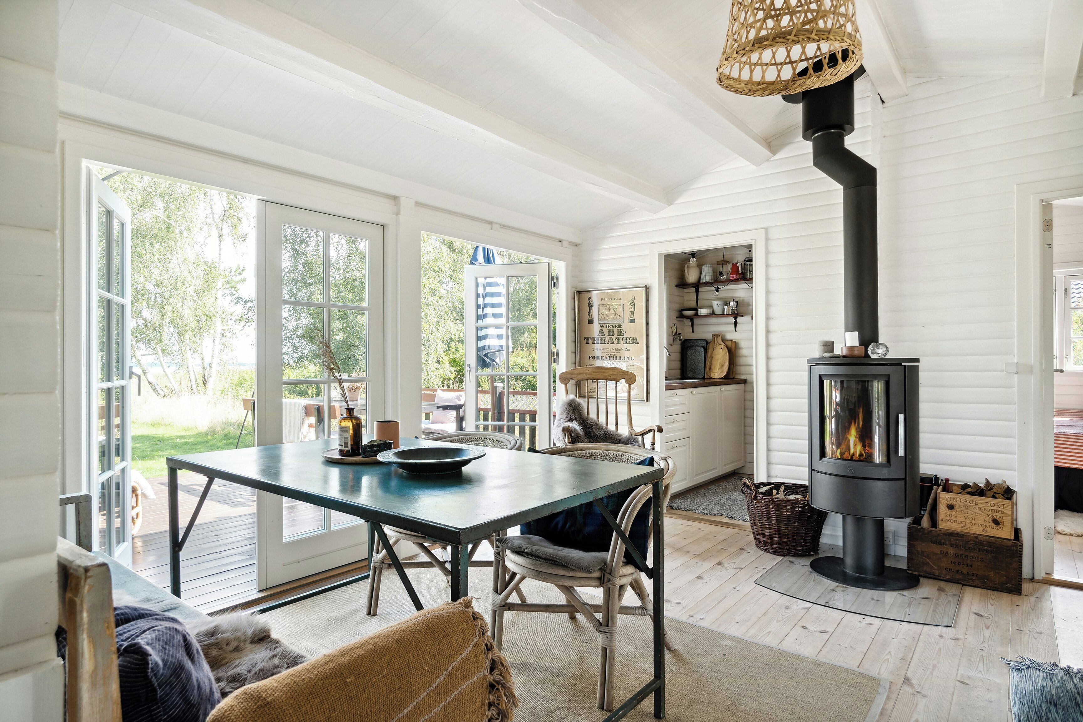 A cozy interior with a dining area, a fireplace, and a view of the outdoors.