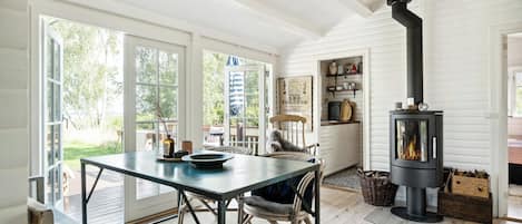 A cozy interior with a dining area, a fireplace, and a view of the outdoors.
