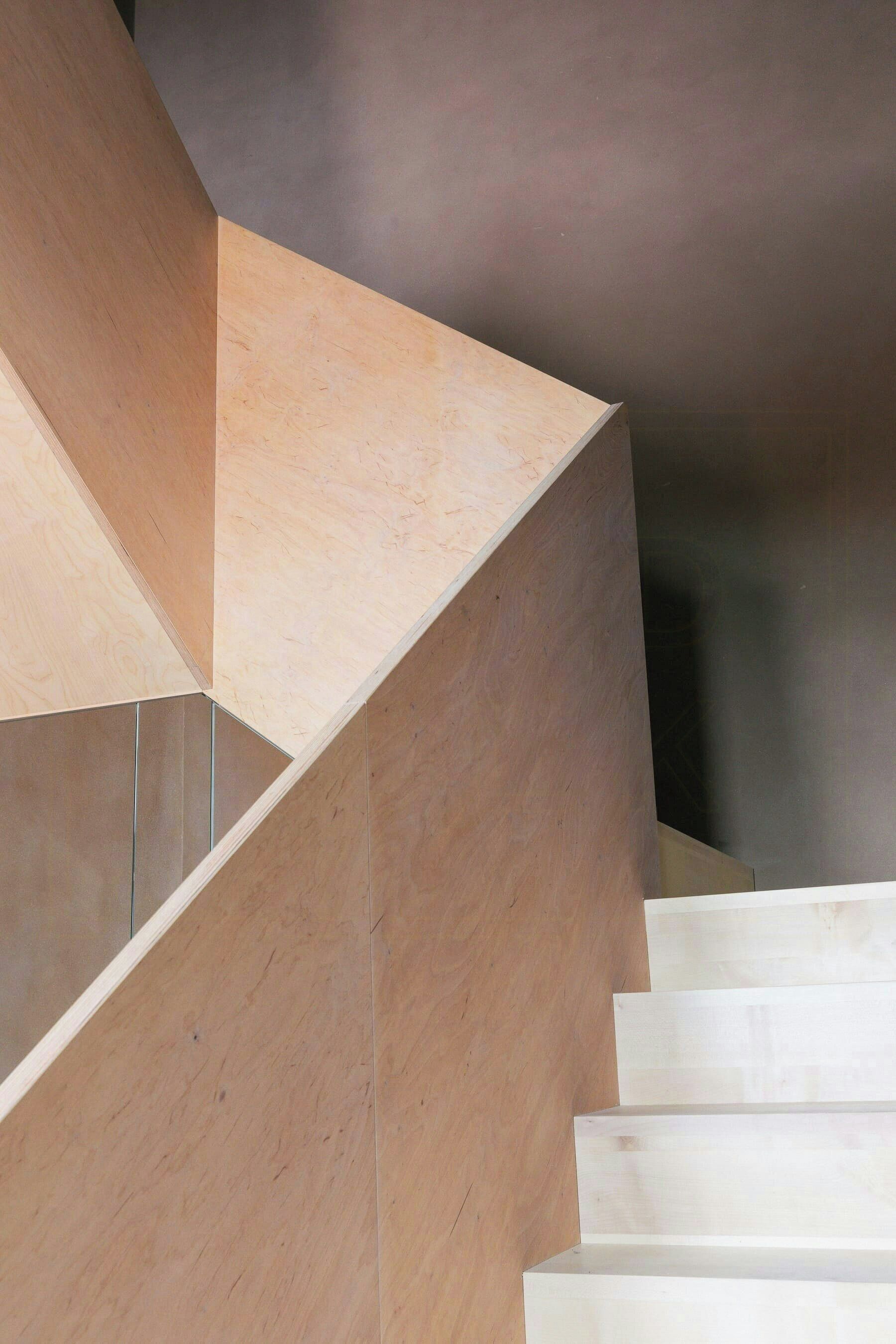 A modern staircase with a minimalist design, made of light-colored materials.