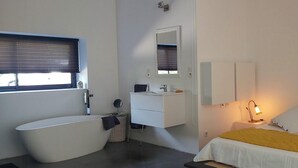 Ein modernes Badezimmer mit einer Badewanne, einem Waschbecken und einem Spiegel.