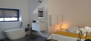 Ein modernes Badezimmer mit einer Badewanne, einem Waschbecken und einem Spiegel.