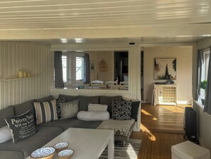 Ein Wohnzimmer mit Sofa, Couchtisch und einer Vitrine mit Dekoration.