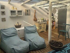 Ein Zimmer mit Holzboden, einem weißen Schrank, einem blauen Stuhl und einem blauen Sitzsack.