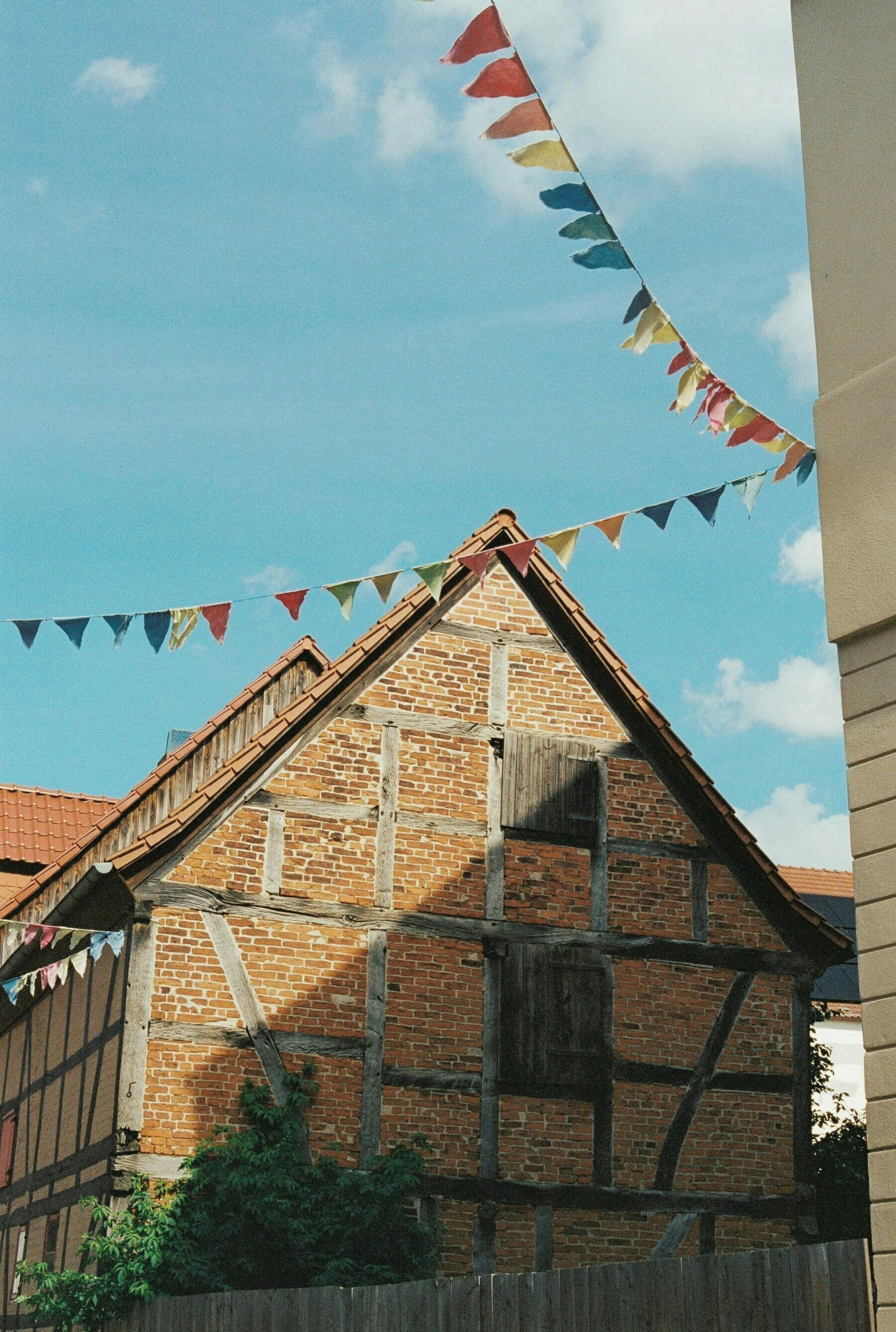 Ein traditionelles Fachwerkhäuschen mit einem steilen Dach, einer Holztreppe und einer Backsteinmauer.