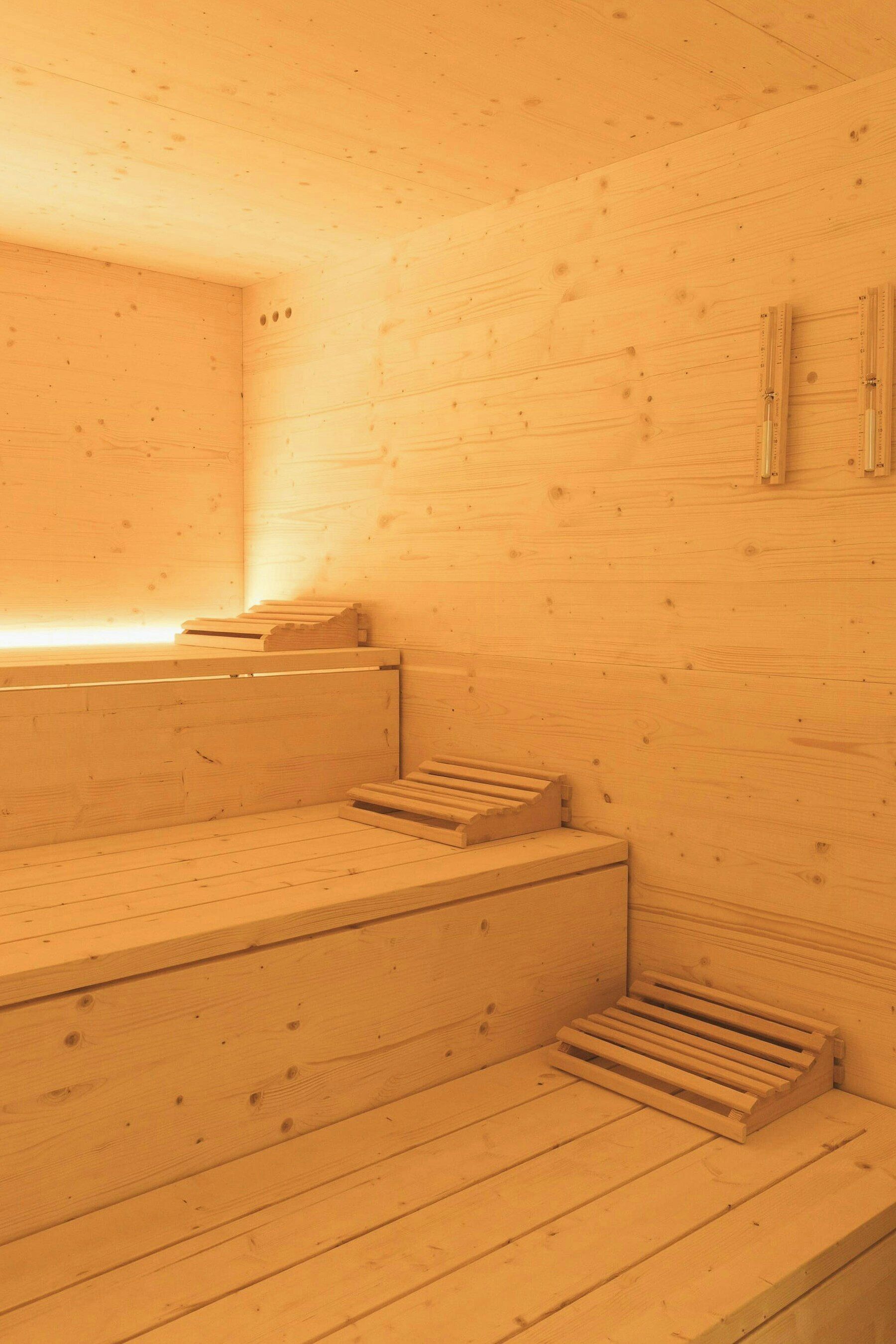 Una sauna de madera con bancos y suelo inclinado.