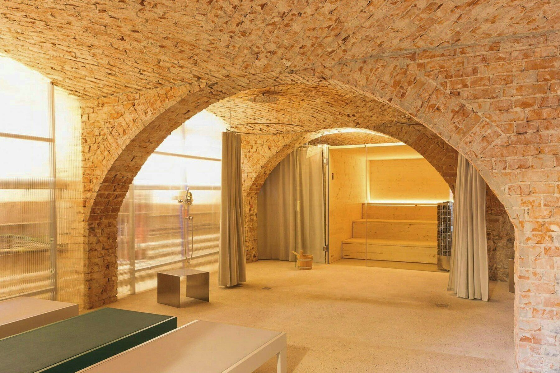 Une pièce dotée de plafonds voûtés en briques, d’un espace douche et d’un lit.