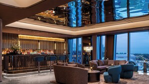 A modern lobby with a bar, seating area, and large windows offering a city view. - Crystal Orange Hotel Shenzhen Bay MixC (Shenzhen)
