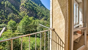 Un balcone con ringhiera in metallo che si affaccia su un paesaggio montuoso.