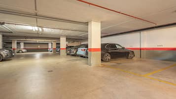Uma garagem subterrânea com vários níveis, pisos de concreto, pilares e vagas demarcadas.