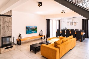 A modern living room with a large sofa, a flat-screen TV, and a fireplace. - Villa Anastazija Family Retreat With Pool (Sveta Nedelja)