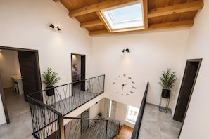 A multi-level interior with a skylight, a clock on the wall, and potted plants. - Villa Anastazija Family Retreat With Pool (Sveta Nedelja)