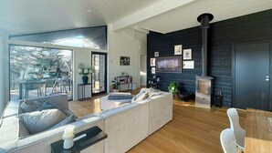 Ein modernes Wohnzimmer mit einer großen Couch, einem Esstisch und einem Kamin.
