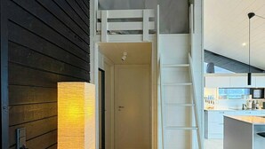 Ein modernes Interieur mit Schlafzimmer im Obergeschoss, einer Treppe und einer Küchenzeile.