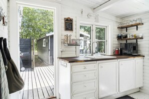 Una cocina con armarios blancos, encimera de madera y una pizarra con escritura.