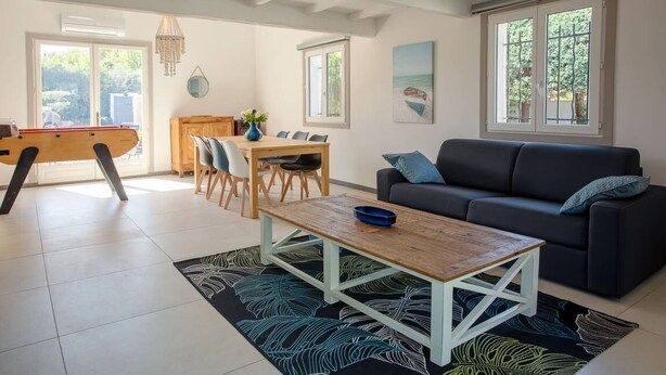 A living room with a sofa, coffee table, dining table, and chairs. There is a pool table in the background. - SPACIOUS VILLA, TENNIS COURT, LARGE PARK (Cuers)