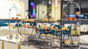 Un présentoir à desserts composé de plusieurs étages et proposant une grande variété de pâtisseries.