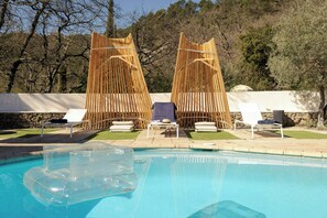 Ein Schwimmbecken mit Liegestühlen und einem Holzzaun.