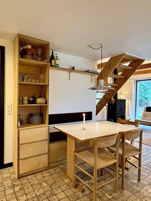 Eine kleine Küche mit Holzausstattung, einem Esstisch und einer integrierten Bank.