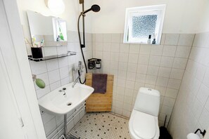 Ein Badezimmer mit Waschbecken, Toilette, Dusche und einem Fenster.