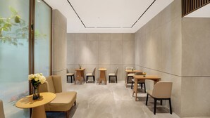 A modern interior with a seating area, tables, and a decorative vase.