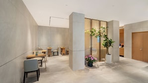A modern interior with a dining area, wooden cabinets, and potted plants.