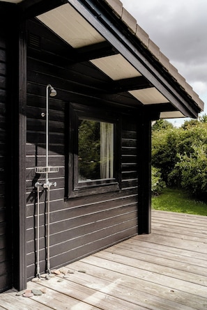A wooden deck with a window and a metal light fixture. - Sea view and relaxation in Mols Hills (Rønde)